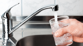 a person pouring a glass of water.